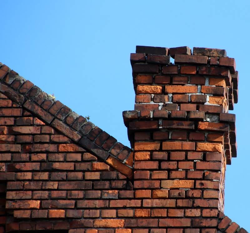 Damaged chimney on an Plantation home showing cracks and missing mortar